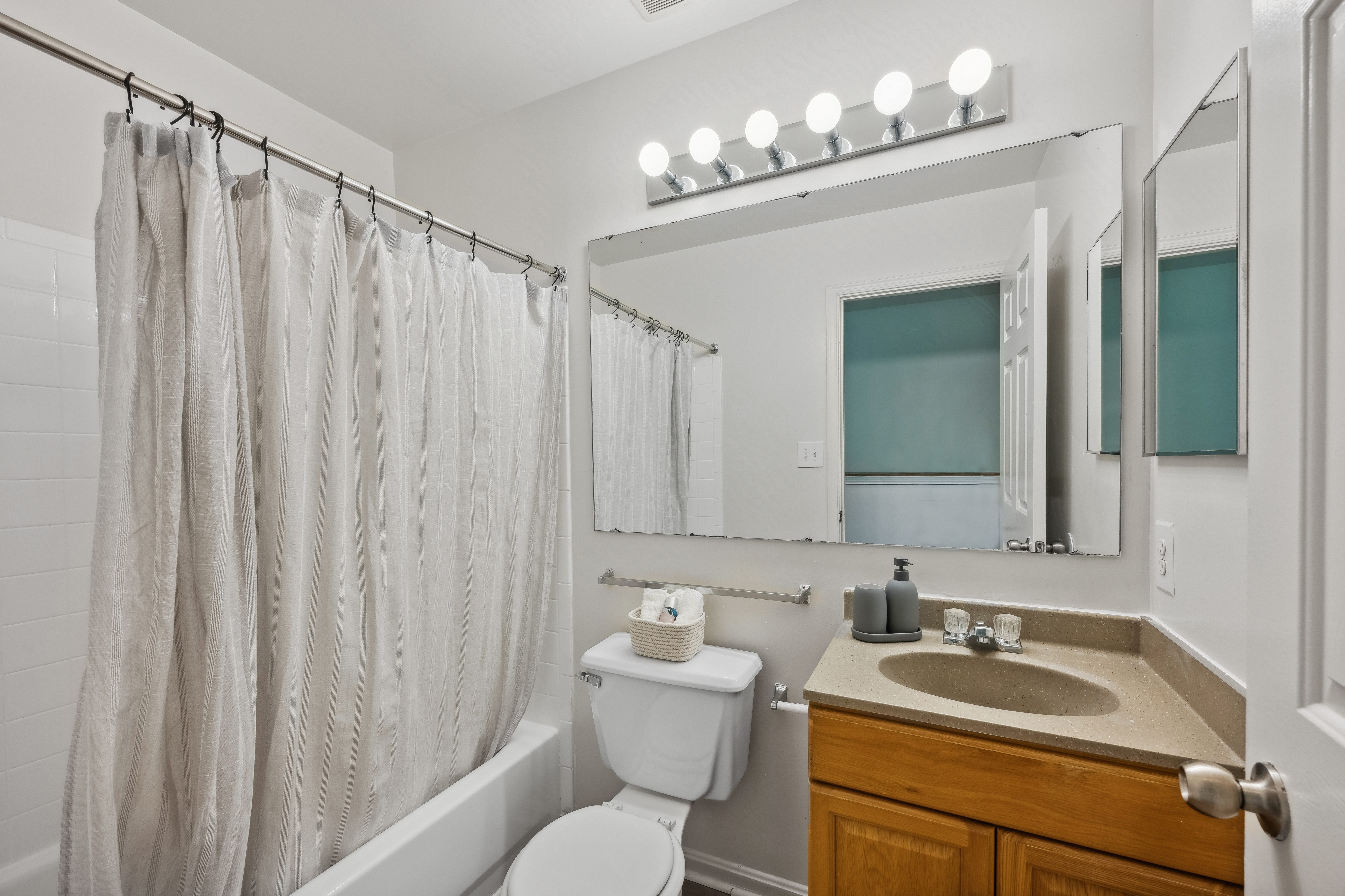 A bathroom with a toilet, sink, and shower curtain.